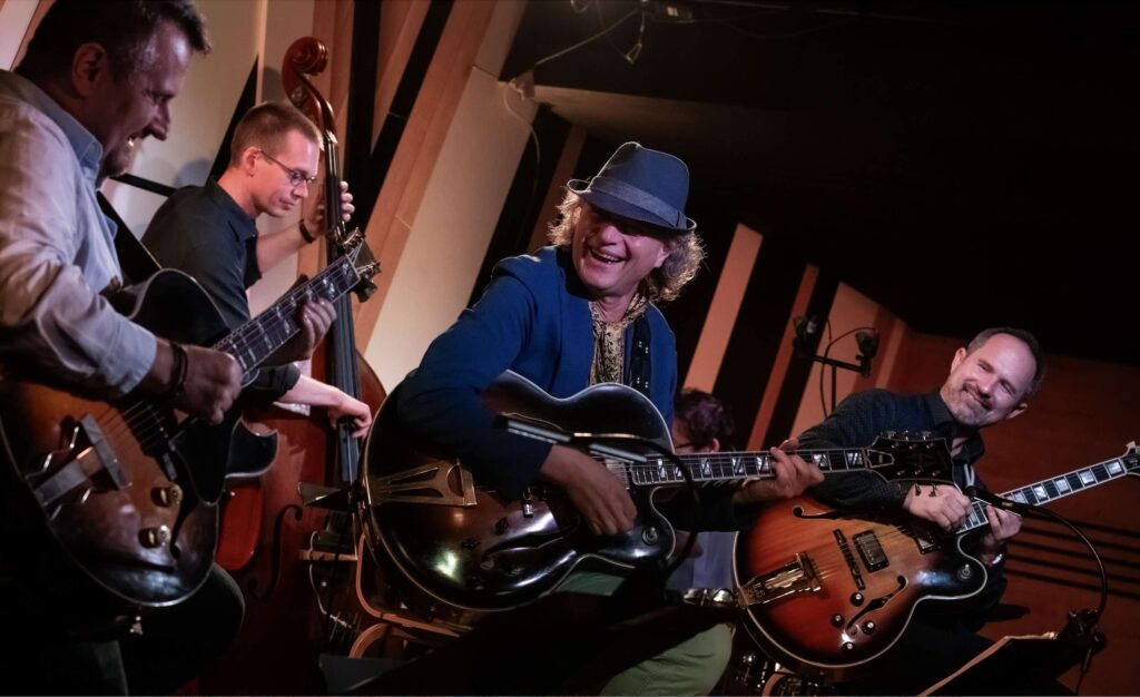 a Jazz band, 3 electric guitarists, a double bass player and drummer on the stage