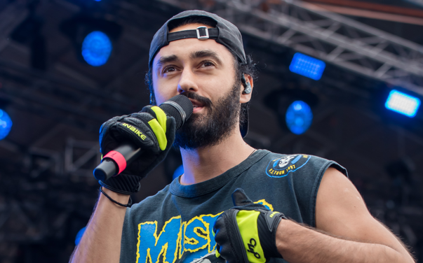Picture of the Estonian rapper, Artemi Ivanov, holding a microphone and singing on the stage