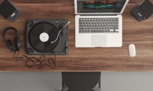 Top view of a music production desk with a laptop and turntable setup for modern audio production.