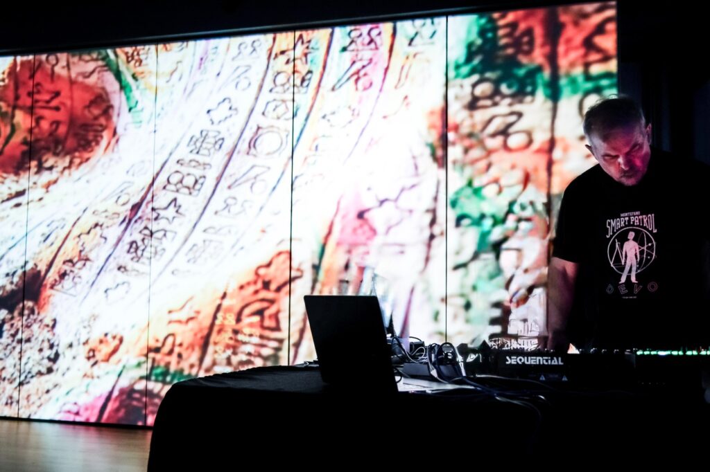 Electronic musician on the stage with live projection behind him performing live in concert. Neuropa Paolo Bragaglia