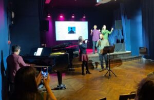Pianist performing on the black Estonia piano, a female and a male singer singing and two actors on the stage. MANUS: The Hands, When Music Becomes Philosophy